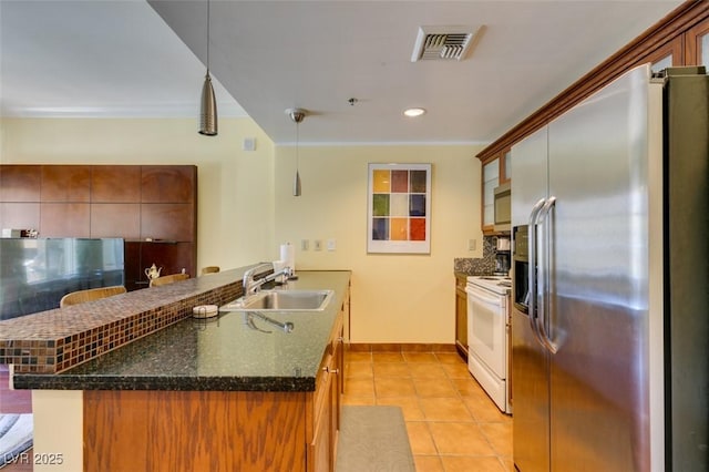 kitchen featuring light tile patterned floors, visible vents, a sink, stainless steel appliances, and backsplash