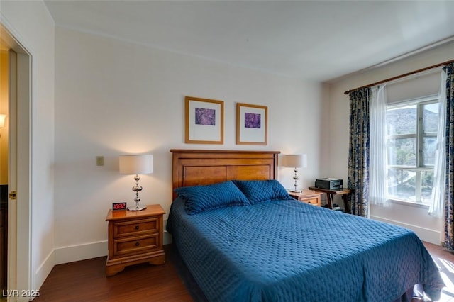 bedroom with baseboards and wood finished floors