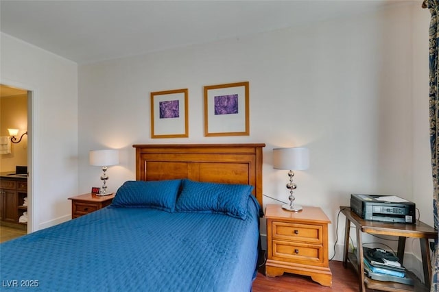 bedroom featuring wood finished floors and ensuite bathroom