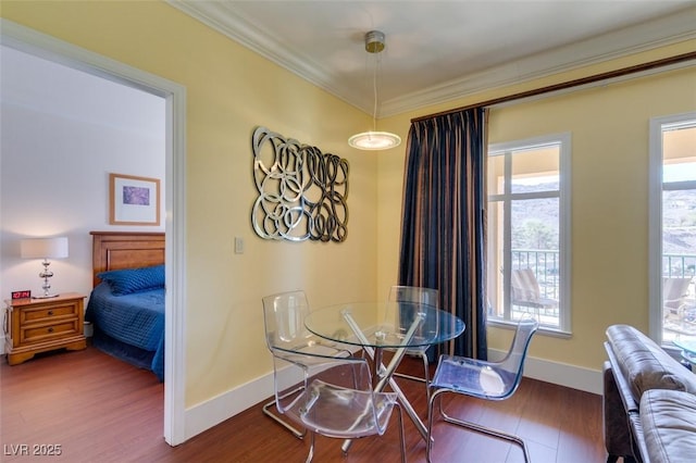 dining room with ornamental molding, wood finished floors, and baseboards