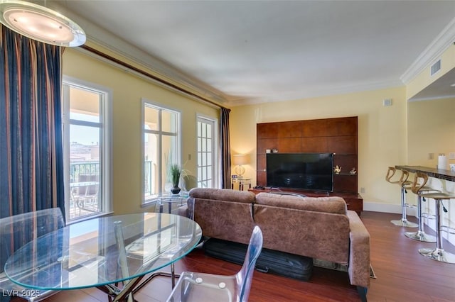 dining room with baseboards, dark wood finished floors, visible vents, and crown molding