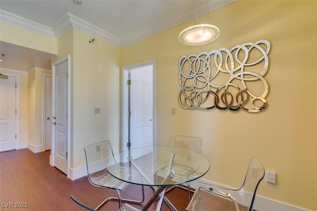 dining room featuring baseboards, ornamental molding, and wood finished floors