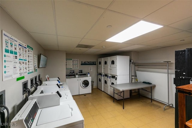 community laundry room featuring light floors, washer and clothes dryer, and stacked washer / dryer