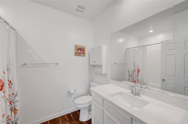 bathroom with toilet, wood finished floors, visible vents, vanity, and baseboards