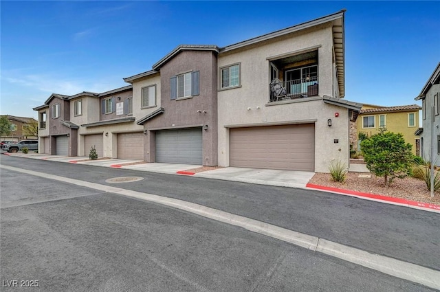 view of property featuring a garage, a residential view, and stucco siding