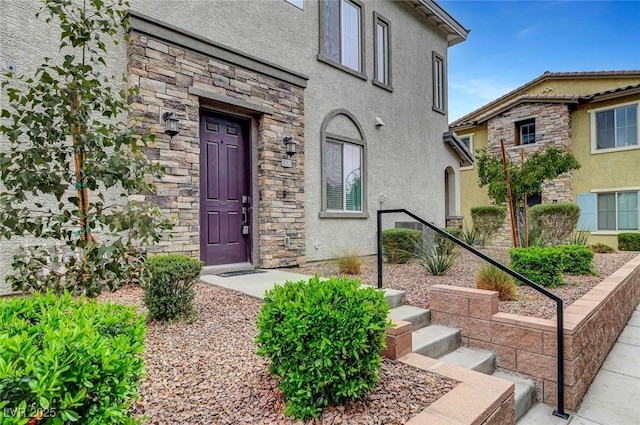 doorway to property with stone siding and stucco siding