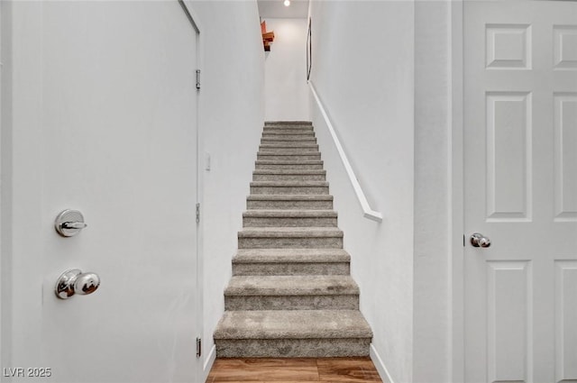 staircase with wood finished floors and baseboards