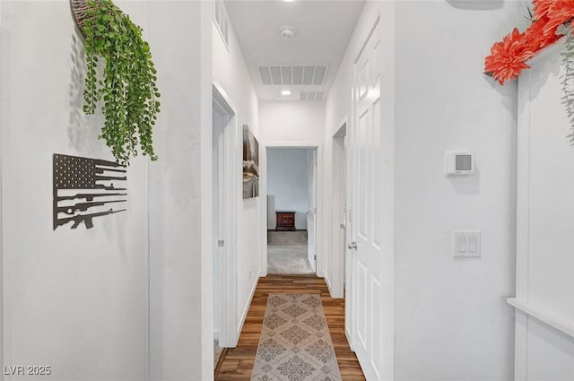 corridor featuring visible vents and wood finished floors