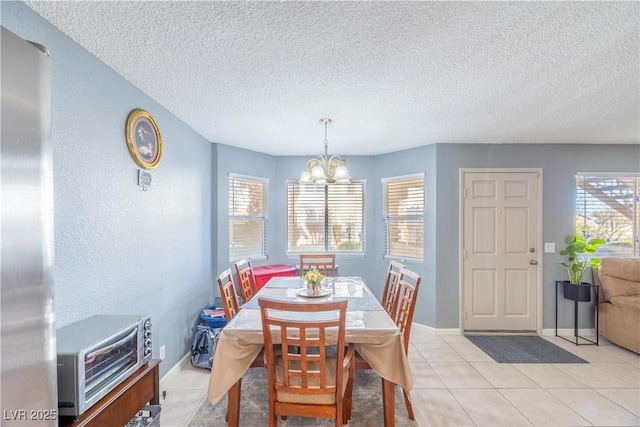 dining space featuring a chandelier, light tile patterned flooring, plenty of natural light, and a textured ceiling