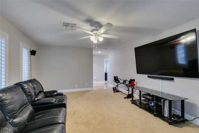 living area with baseboards, visible vents, ceiling fan, and carpet flooring