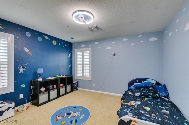 bedroom with a textured ceiling, carpet floors, visible vents, and baseboards