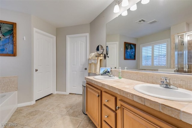 bathroom with a garden tub, a sink, and visible vents