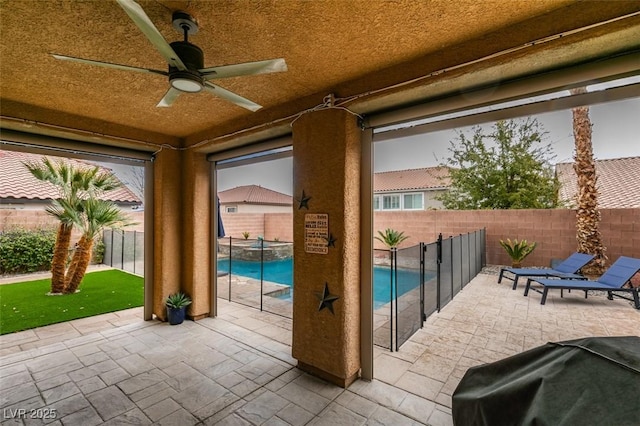 view of patio / terrace featuring ceiling fan, area for grilling, a fenced backyard, and a pool with connected hot tub