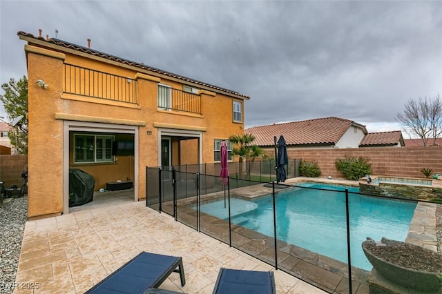 view of pool featuring a patio area, a fenced backyard, a pool with connected hot tub, and grilling area