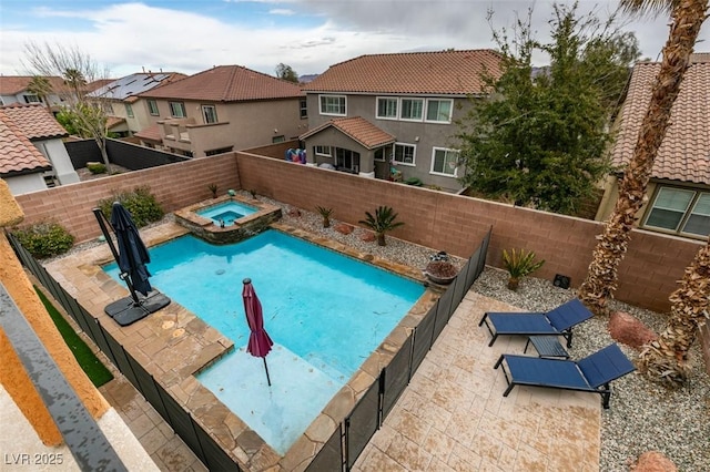 view of swimming pool featuring a residential view, a patio area, a fenced backyard, and a pool with connected hot tub