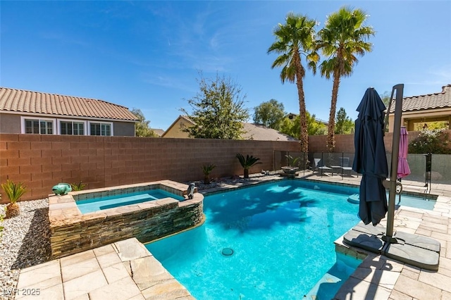 view of swimming pool featuring a patio area, a fenced backyard, and a pool with connected hot tub