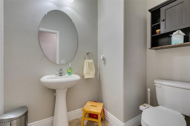 half bath with toilet and baseboards