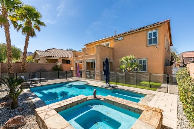 view of swimming pool with a patio, fence, and a pool with connected hot tub