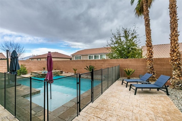 view of pool with a patio area, a fenced backyard, and a pool with connected hot tub