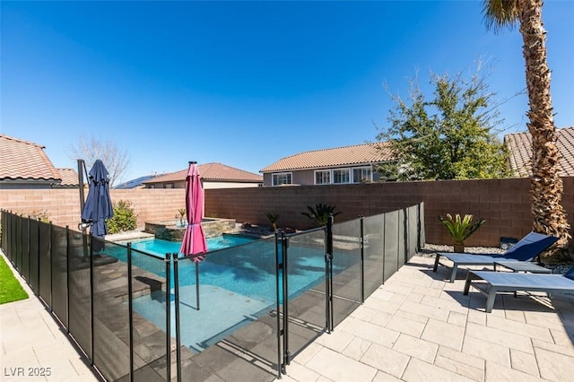 view of swimming pool featuring a patio, a fenced backyard, and a pool with connected hot tub