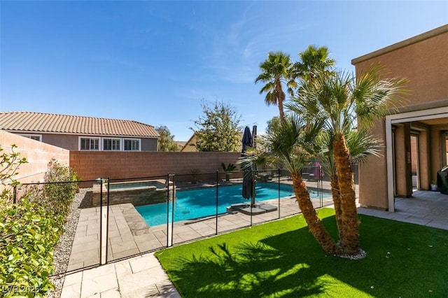 view of pool featuring a pool with connected hot tub, a fenced backyard, a lawn, and a patio