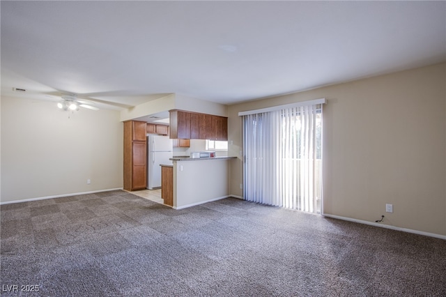 kitchen with freestanding refrigerator, open floor plan, and light carpet