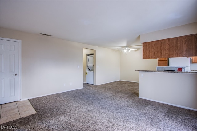 unfurnished living room featuring visible vents, carpet flooring, a ceiling fan, and baseboards