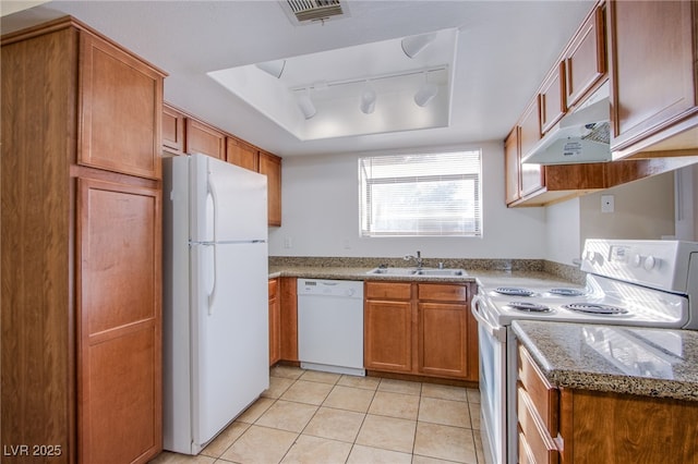 kitchen with under cabinet range hood, white appliances, a sink, visible vents, and a tray ceiling