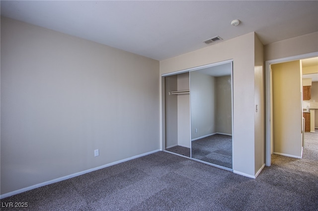 unfurnished bedroom featuring carpet floors, a closet, visible vents, and baseboards