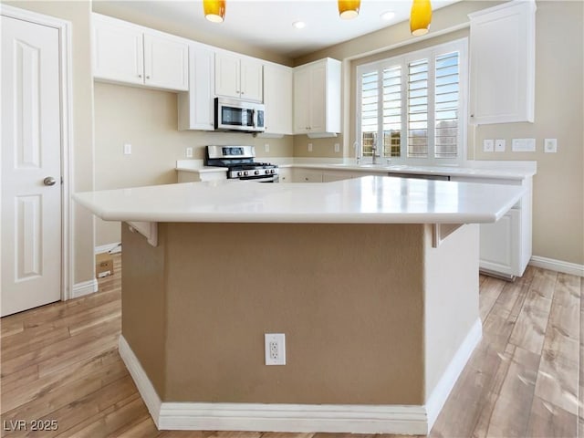 kitchen with white cabinetry, light countertops, light wood-style floors, and appliances with stainless steel finishes