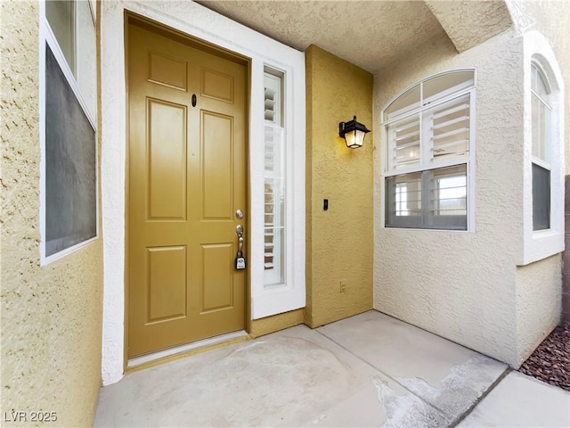 view of exterior entry with stucco siding