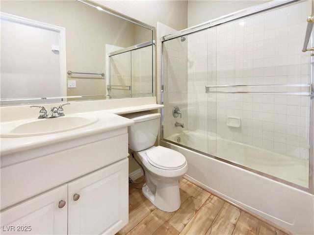 full bath with toilet, shower / bath combination with glass door, vanity, and wood finished floors