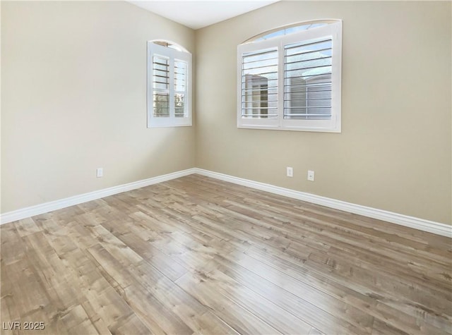 unfurnished room featuring baseboards and wood finished floors