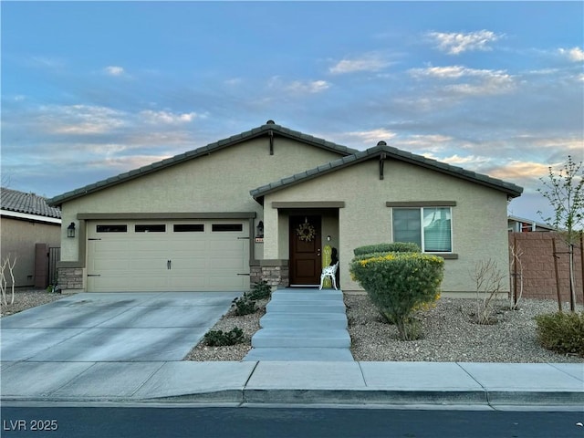 view of front of property featuring driveway, an attached garage, fence, and stucco siding