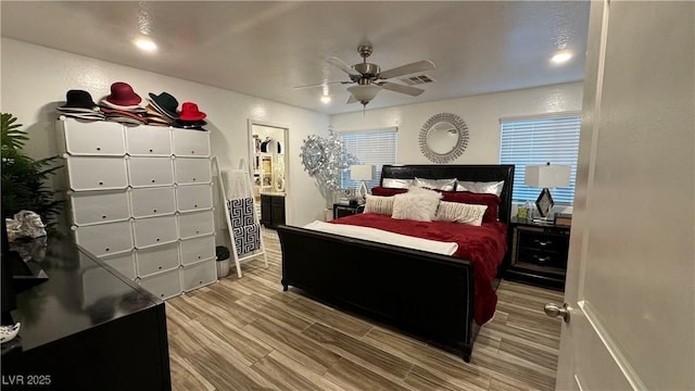 bedroom with ensuite bath, wood tiled floor, visible vents, and a ceiling fan