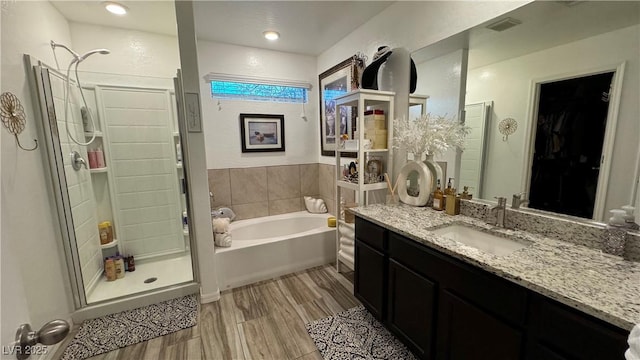 full bath with a stall shower, visible vents, a garden tub, and vanity