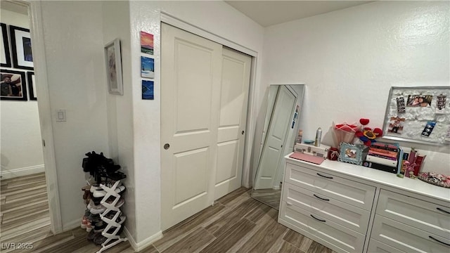 hallway featuring wood tiled floor and baseboards