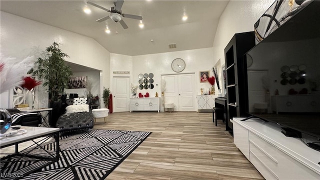 living room with high vaulted ceiling, visible vents, a ceiling fan, and wood finish floors