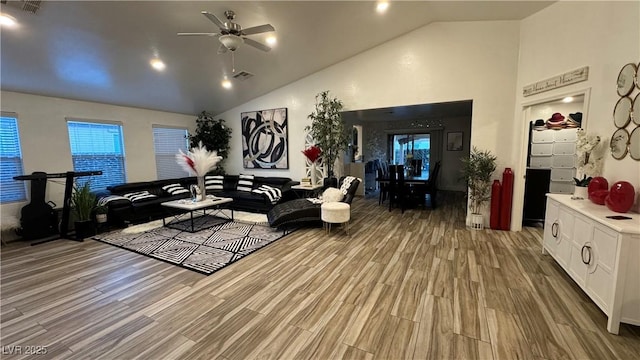 living room with light wood-style floors, visible vents, high vaulted ceiling, and a ceiling fan