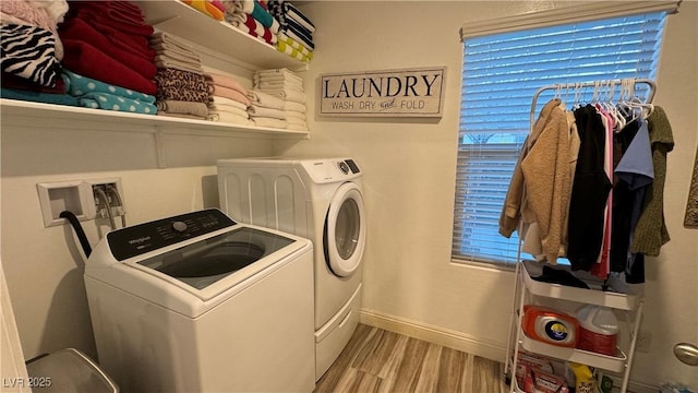 laundry area featuring laundry area, separate washer and dryer, wood finished floors, and baseboards