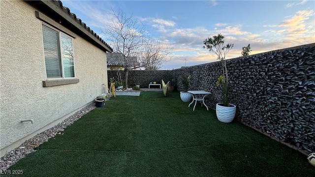 yard at dusk with a fenced backyard