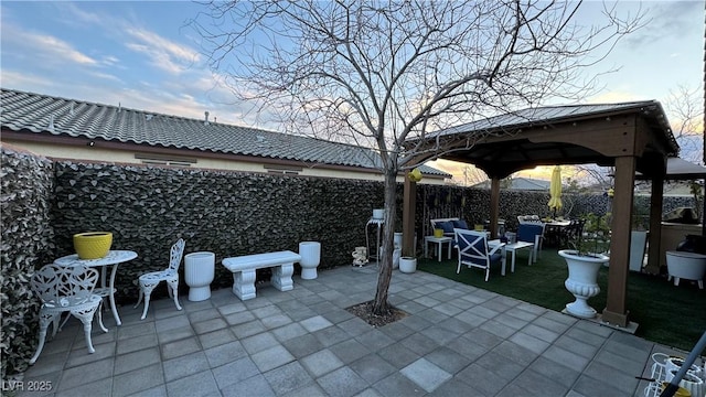 view of patio featuring fence and a gazebo