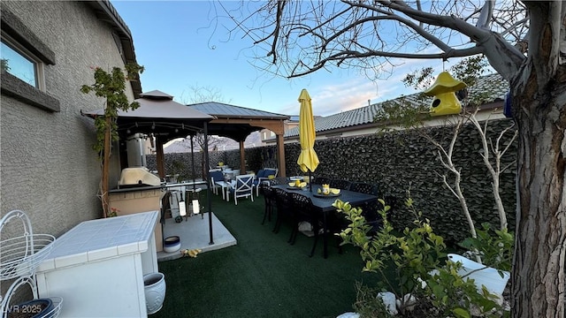 view of patio / terrace with outdoor dining area, a fenced backyard, an outdoor living space, and a gazebo