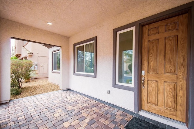 doorway to property with a patio area and stucco siding