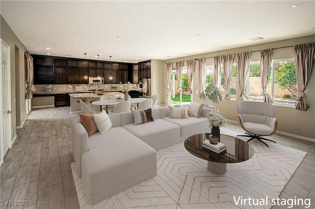 living area with light wood-type flooring, baseboards, and recessed lighting