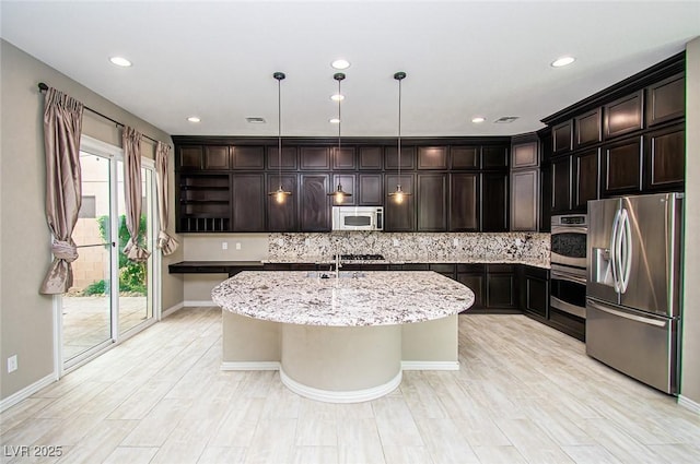 kitchen with light stone counters, a center island with sink, open shelves, stainless steel appliances, and decorative backsplash