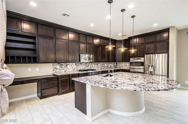 kitchen with dark brown cabinets, visible vents, stainless steel appliances, and a sink