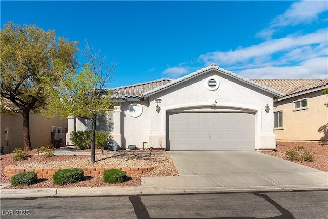 view of front facade with concrete driveway, a tiled roof, a garage, and stucco siding