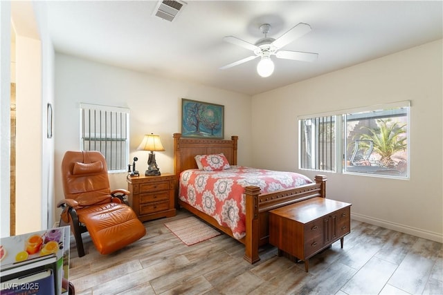 bedroom with visible vents, baseboards, light wood-style floors, and a ceiling fan