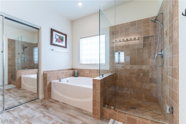 full bath with a shower stall, a garden tub, and wood finished floors